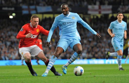 Manchester United's English striker Wayne Rooney (L) vies with Manchester City's Ivorian midfielder Yaya Toure in April 2012. A glut of Premier League sides including Arsenal, Manchester City and Manchester United are touring Asia this month hoping to cash in on the region's unquenchable thirst for English football