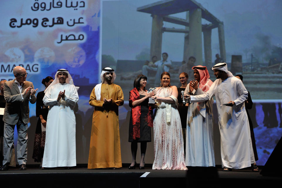 DUBAI, UNITED ARAB EMIRATES - DECEMBER 16: HH Sheikh Mansoor bin Mohammed bin Rashid Al Maktoum and producer Dina Farouk with the Muhr Arab Feature Special Jury Prize award on stage during the Closing Ceremony on day eight of the 9th Annual Dubai International Film Festival held at the Madinat Jumeriah Complex on December 16, 2012 in Dubai, United Arab Emirates. (Photo by Gareth Cattermole/Getty Images for DIFF)