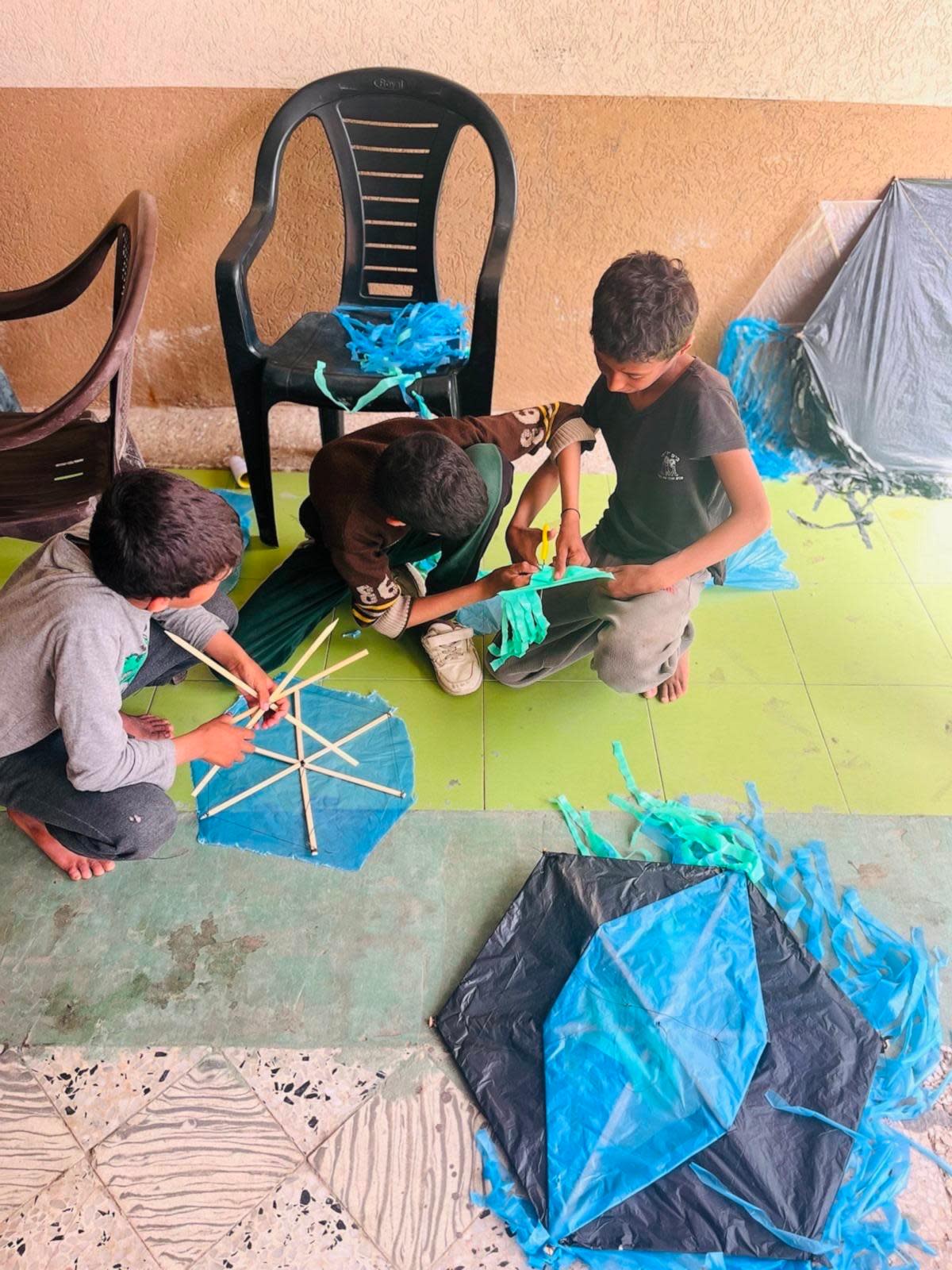 PHOTO: AFSC volunteers help children make kites for the festival in Rafah. (American Friends Service Committee)