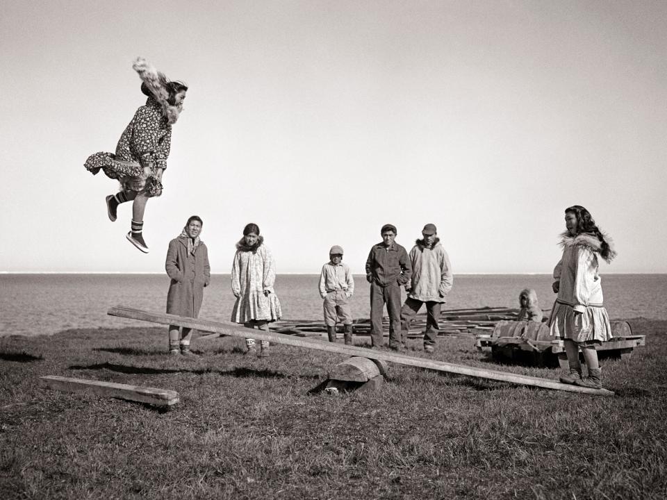 ALASKAN ESKIMO 1940s 1950s alaskan eskimo children and teens playing a game of jumpboard a kind of seesaw game arctic kotzebue alaska USA