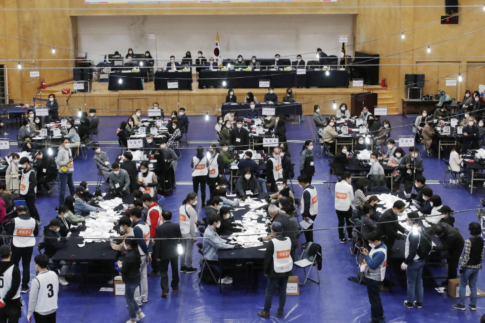 National Election Commission officials sort out ballots for counting at the Seoul mayoral by-election in Seoul, South Korea, Wednesday, April 7, 2021. (AP Photo/Lee Jin-man)