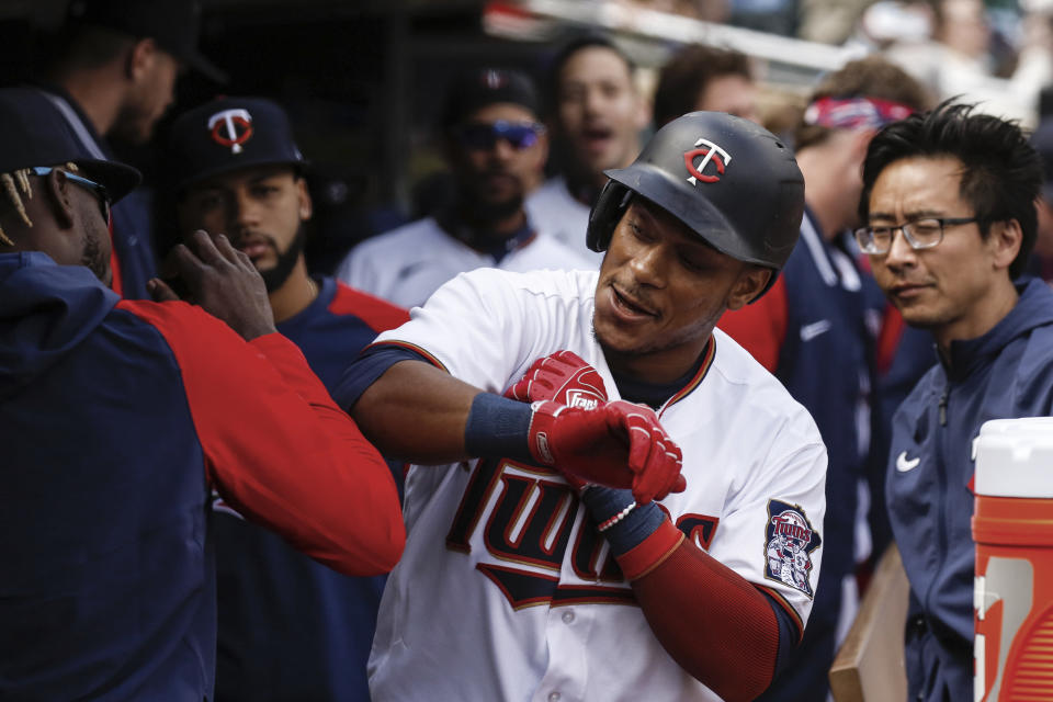 Minnesota Twins second baseman Jorge Polanco (11) celebrates with coaches and teammates after hitting a solo home run against the Seattle Mariners during the fourth inning of a baseball game Sunday, April 10, 2022, in Minneapolis. (AP Photo/Nicole Neri)