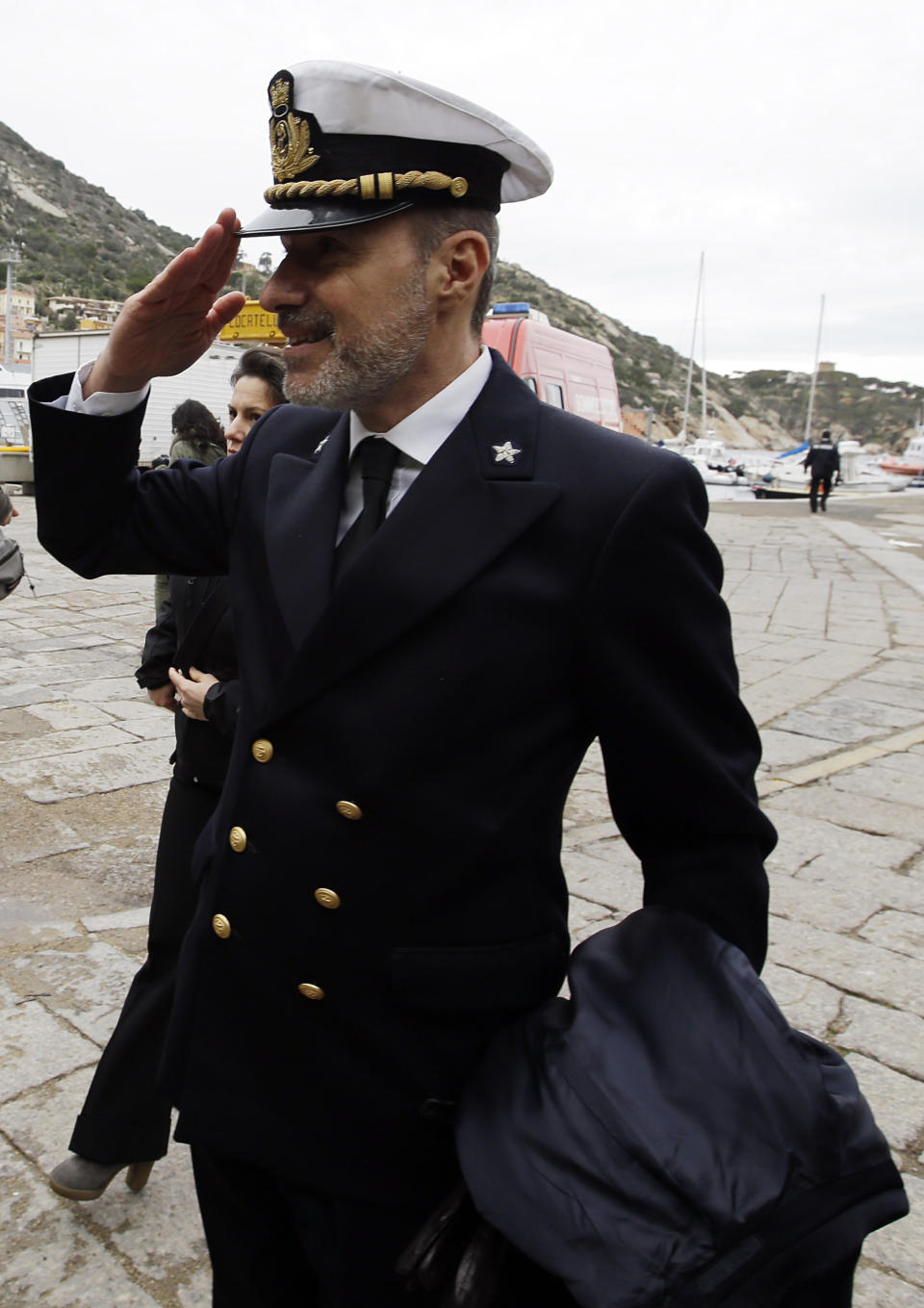 Italian Coast Guard Capt. Gregorio De Falco salutes as he arrives on the Tuscan Island Isola del Giglio, Italy, Sunday, Jan. 13, 2013.  De Falco was heard ordering the captain, who had abandoned the ship with his first officers, back on board to oversee the evacuation. But Capt. Francesco Schettino resisted the order, saying it was too dark and the ship was tipping dangerously. Survivors of the Costa Concordia shipwreck and relatives of the 32 people who died marked the first anniversary of the grounding Sunday. (AP Photo/Gregorio Borgia)