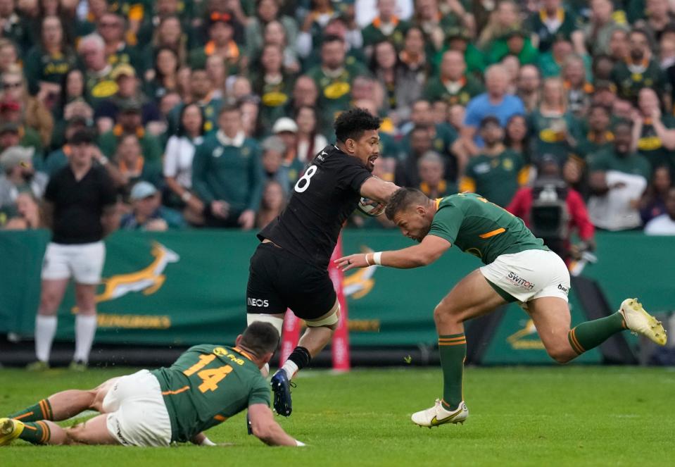 New Zealand's Ardie Savea, center, is challenged by South Africa's Handre Pollard (AP)