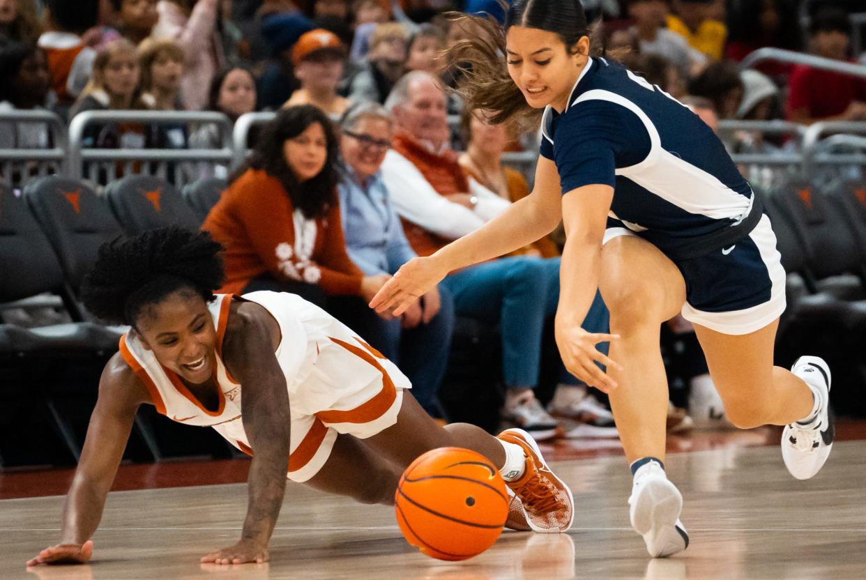 Texas guard Rori Harmon and Oral Roberts guard Hannah Cooper fall trying to win the ball in the first half of the Longhorns' game against the Oral Roberts Golden Eagles at Moody Center on Wednesday. Harmon filled the stat sheet in the win.
