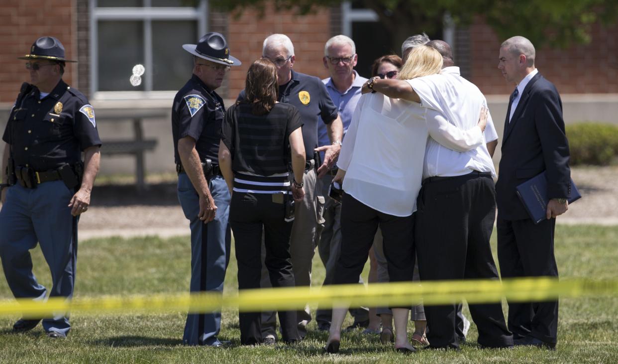 Authorities huddle outside Noblesville West Middle School just before a news conference in 2018 after a then 13-year-old boy opened fire at the school.