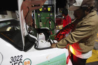 Un taxista llena con gasolina varios contenedores en su maletero después de esperar durante horas en una gasolinera en Valle de Bravo, México, la noche del 30 de diciembre de 2016. (AP Foto/Marco Ugarte)