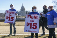 Activists appeal for a $15 minimum wage near the Capitol in Washington, Thursday, Feb. 25, 2021. The $1.9 trillion COVID-19 relief bill being prepped in Congress includes a provision that over five years would hike the federal minimum wage to $15 an hour. (AP Photo/J. Scott Applewhite)