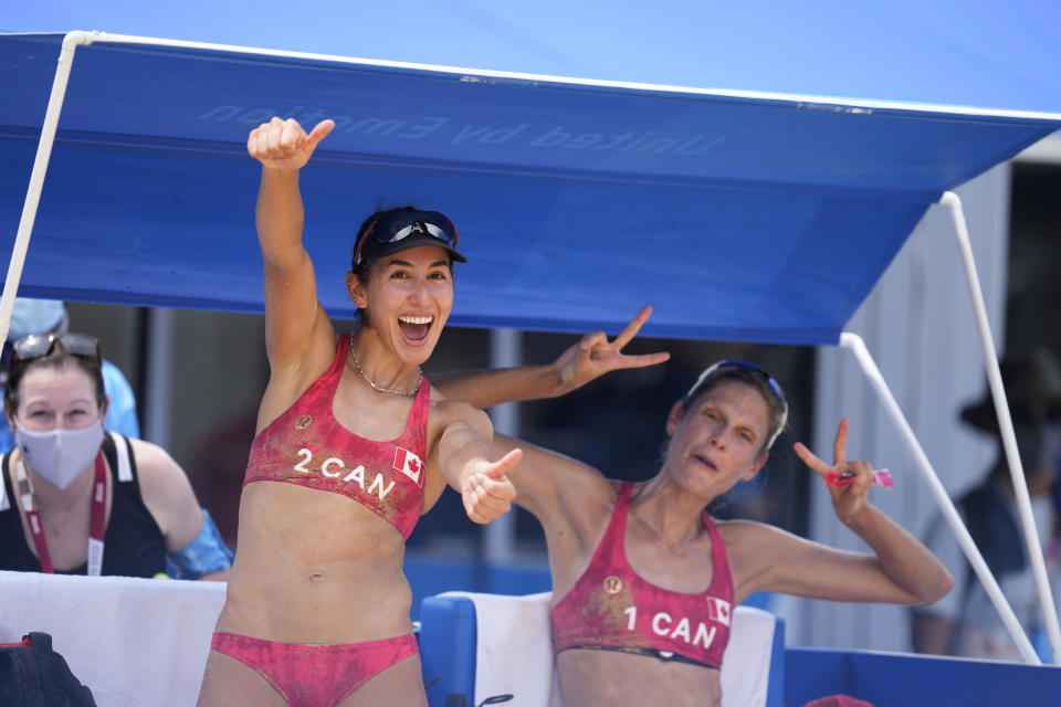 Sarah Pavan, right, of Canada, and teammate Melissa Humana-Paredes celebrate after winning a women's beach volleyball match against Spain at the 2020 Summer Olympics, Monday, Aug. 2, 2021, in Tokyo, Japan. (AP Photo/Petros Giannakouris)