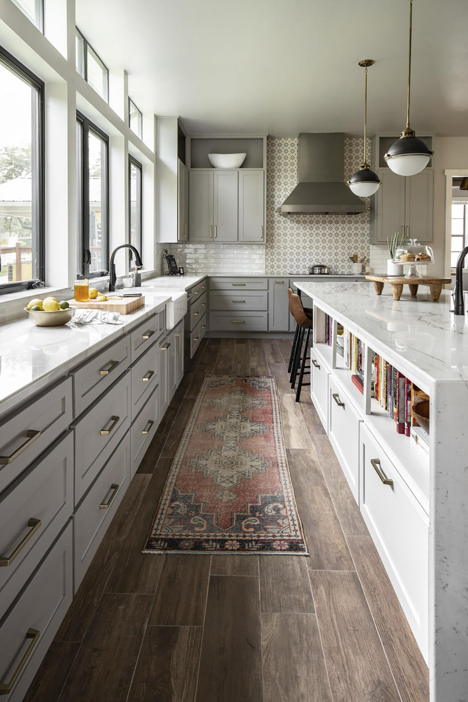 This 2019 photo shows a kitchen designed by interior designer Ashely Moore. In this kitchen Moore used a vintage Moroccan rug which adds warmth and color, and its appealingly worn look blends beautifully with the reclaimed wood floor. (Grace Laird Photography/Moore House Interiors via AP)