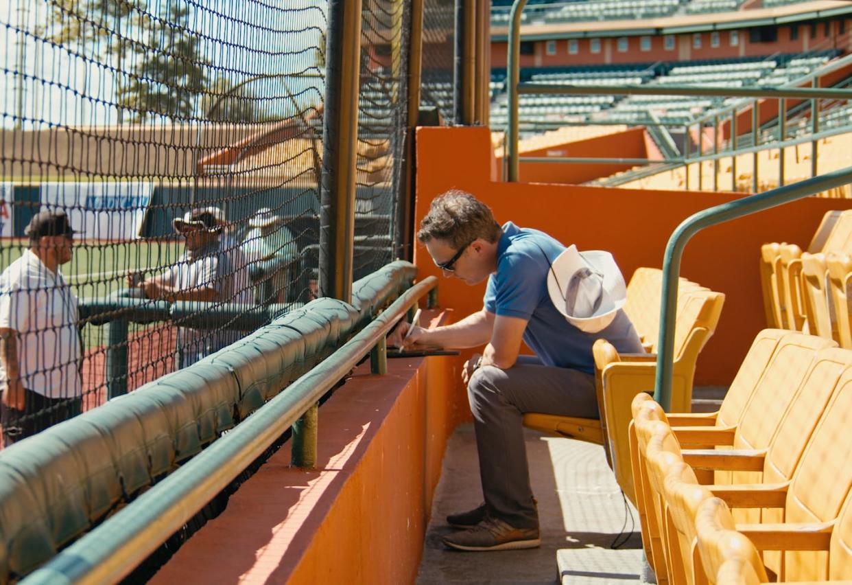 Texas Rangers scout Brian Williams takes notes at Roberto Clemente Stadium in Carolina, Puerto Rico. H. James Gilmore and Tracy Halcomb, <a href="http://creativecommons.org/licenses/by-sa/4.0/" rel="nofollow noopener" target="_blank" data-ylk="slk:CC BY-SA;elm:context_link;itc:0;sec:content-canvas" class="link ">CC BY-SA</a>