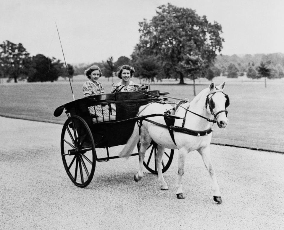 <p>Here, Princesses Elizabeth and Margaret ride through the garden of Windsor Castle. The sisters were evacuees, sent away from Buckingham Palace to keep safe from air raids. Their new home <a href="https://www.rct.uk/resources/activity-challenge-wartime-windsor" rel="nofollow noopener" target="_blank" data-ylk="slk:was set up" class="link ">was set up</a> with loudspeakers to warn of strikes, basement shelters, and blackout curtains to keep the area invisible from the sky. </p>