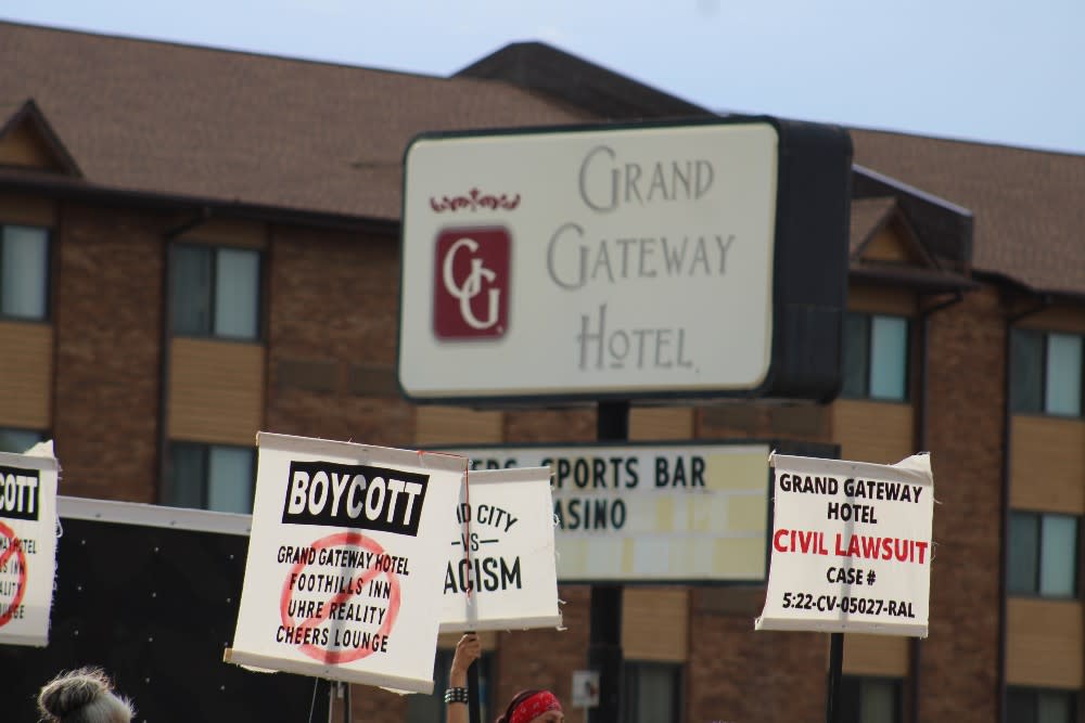 Demonstrators hold signs in protest outside the Grand Gateway Hotel in Rapid City, SD on July 6, 2022. (Photo/Darren Thompson)