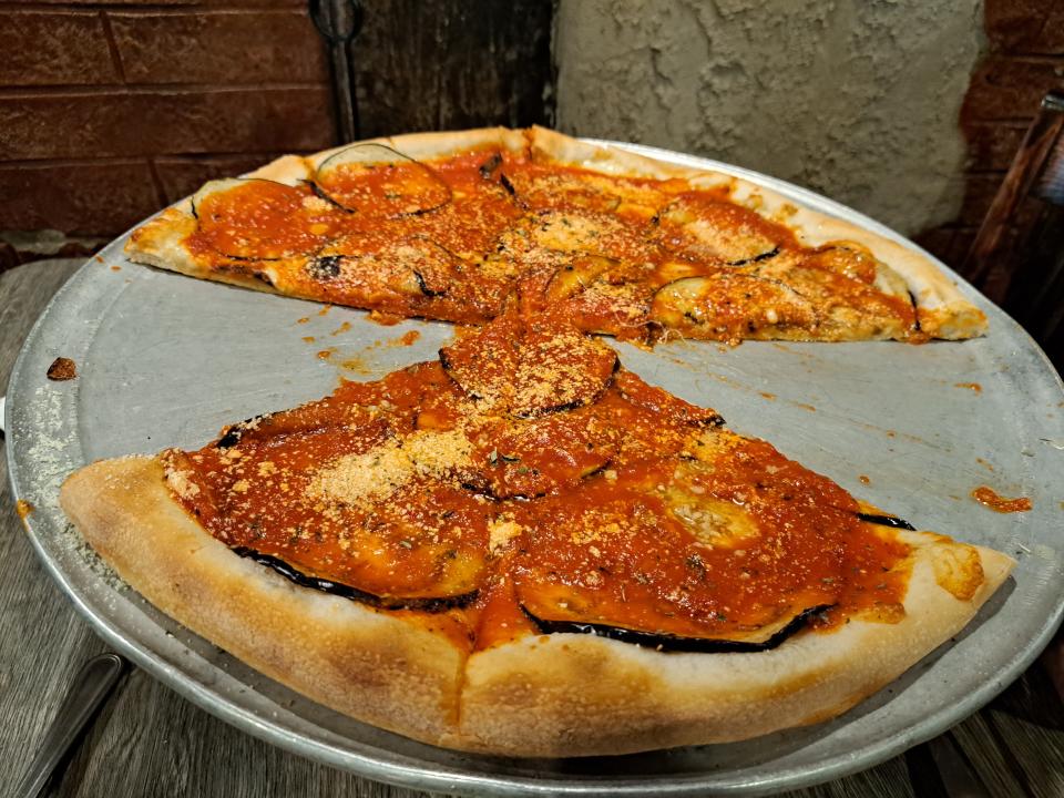 Cafe Napoli in Milltown has advanced to the Final Four in the Delaware Favorite Pizza Challenge. Two slices are missing from this eggplant marinara pizza, purchased by longtime customers Angela and Jim Argento, both of Avondale, Pa. The couple are regulars and said they've been customers at Napoli for about 20 years.