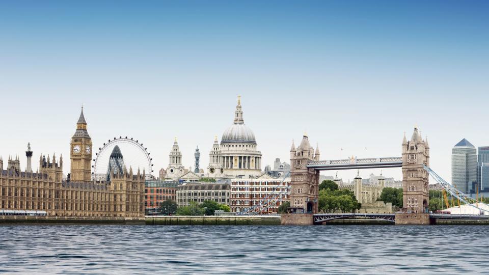 london montage against plain blue sky with river thames in foreground