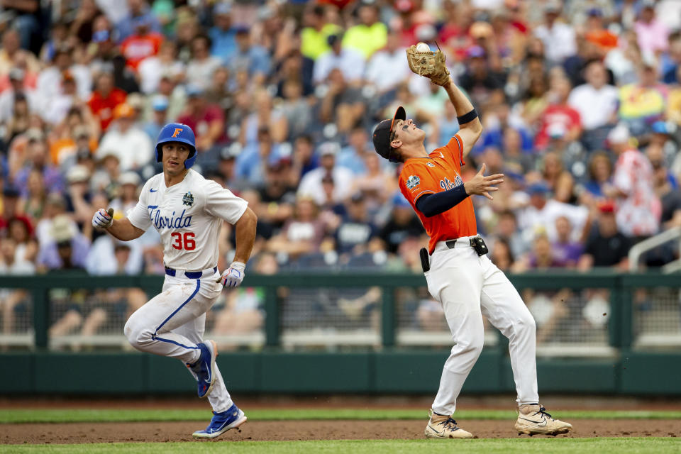 Virginia second baseman Henry Godbout makes a catch for the out on Florida's Wyatt Langford (36) during the third inning of a baseball game at the NCAA College World Series in Omaha, Neb., Friday, June 16, 2023. (AP Photo/John Peterson)