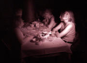 In this false color infrared flashed time exposure image, customers Megan Phares (L), Jamey Titone, (2nd L), Stephanie Wandke (2nd R), and Bonnie Titone (R) experience dining in complete darkness at Opaque in West Hollywood, November 25, 2006. In this weekly dining experience, guests are served a three course gourmet meal in a pitch black dining room by blind waiters. REUTERS/Jason Redmond