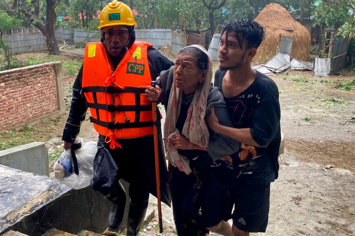 Rescuers help an elderly woman to reach a shelter in Bangladesh (AP)