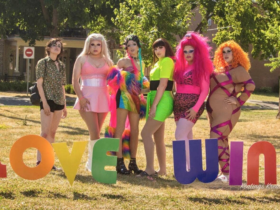 Drag performers pose with the 'love wins' sign at last year's Wortley Pride event in London, Ont. (Keatings Kreations - image credit)