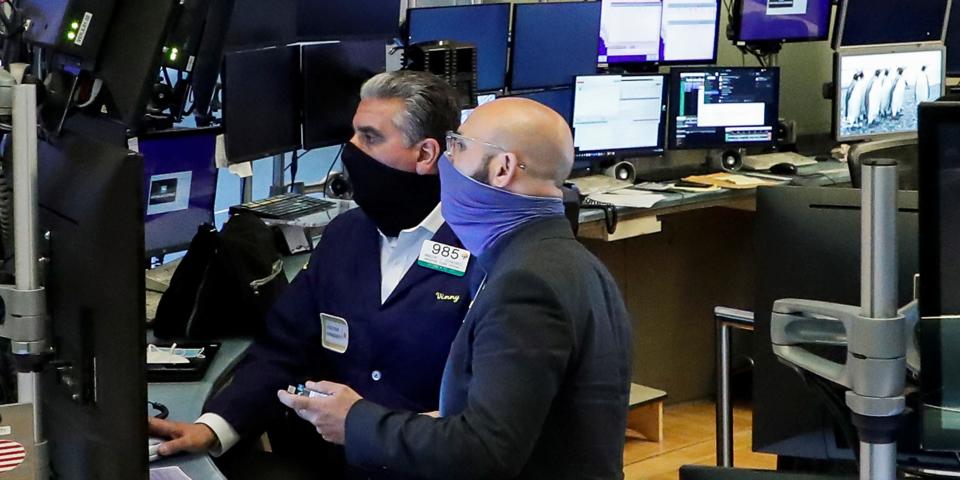 FILE PHOTO: Traders wearing masks work, on the first day of in person trading since the closure during the outbreak of the coronavirus disease (COVID-19) on the floor at the New York Stock Exchange (NYSE) in New York, U.S., May 26, 2020. REUTERS/Brendan McDermid