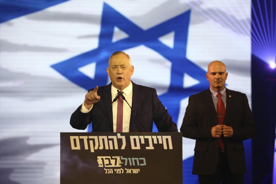 Blue and White party leader Benny Gantz addresses his supporters during election campaign rally in Tel Aviv, Israel, Saturday, Feb. 29, 2020. The Hebrew writing say Must to advance , Blue and White, Israel before everything. (AP Photo/Oded Balilty)