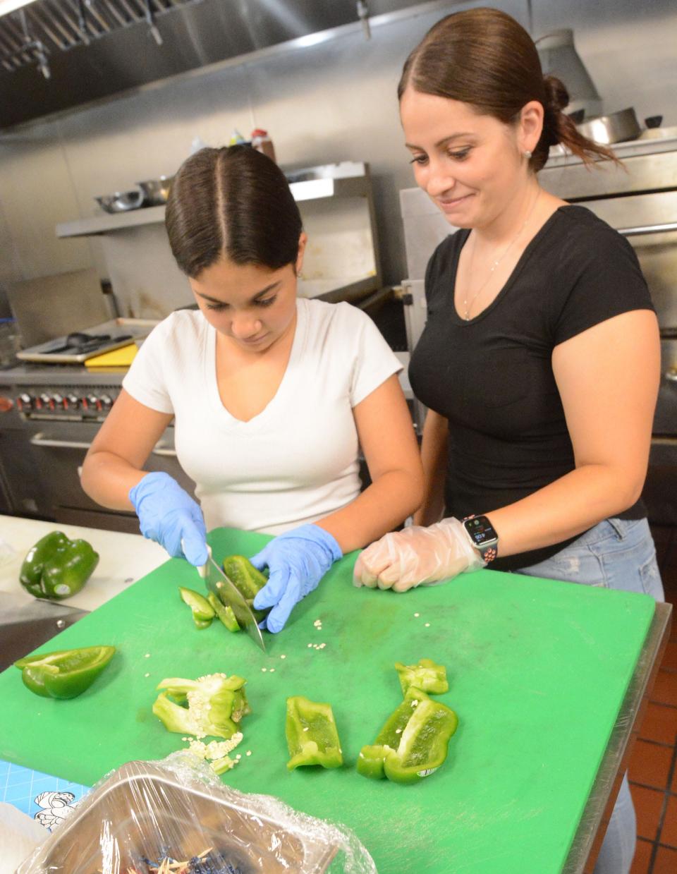 Jeannie Shear, 29, with her daughter Kahleiana, 12, slice peppers at their Off the Griddle restaurant at the Norwich Bowling & Entertainment Center in Norwich Tuesday.