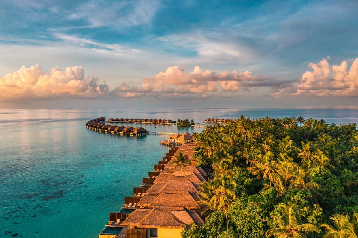 Aerial view of an overwater bungalow resort in the Maldives. 