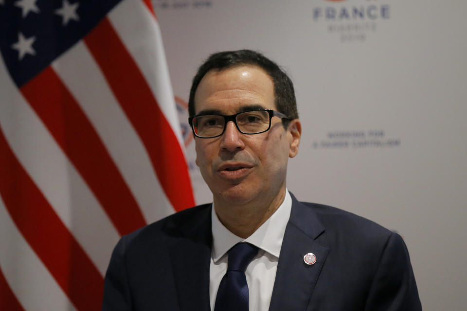 US Treasury Secretary Steve Mnuchin answers reporters after the G-7 Finance Thursday, July 18, 2019 in Chantilly, north of Paris. Top finance officials from the Group of Seven rich democracies are warning that cryptocurrencies like Facebook's Libra should not come into use before "serious regulatory and systemic concerns" are addressed. (AP Photo/Michel Euler)