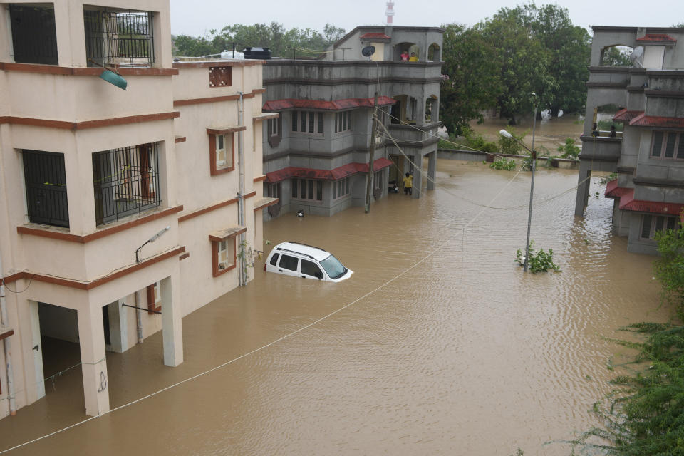 A car is seen partially submerged in the compound of residential quarters of civil hospital employees following heavy winds and incessant rains after landfall of cyclone Biparjoy at Mandvi in Kutch district of Western Indian state of Gujarat, Friday, June 16, 2023. Cyclone Biparjoy knocked out power and threw shipping containers into the sea in western India on Friday before aiming its lashing winds and rain at part of Pakistan that suffered devastating floods last year. (AP Photo/Ajit Solanki)