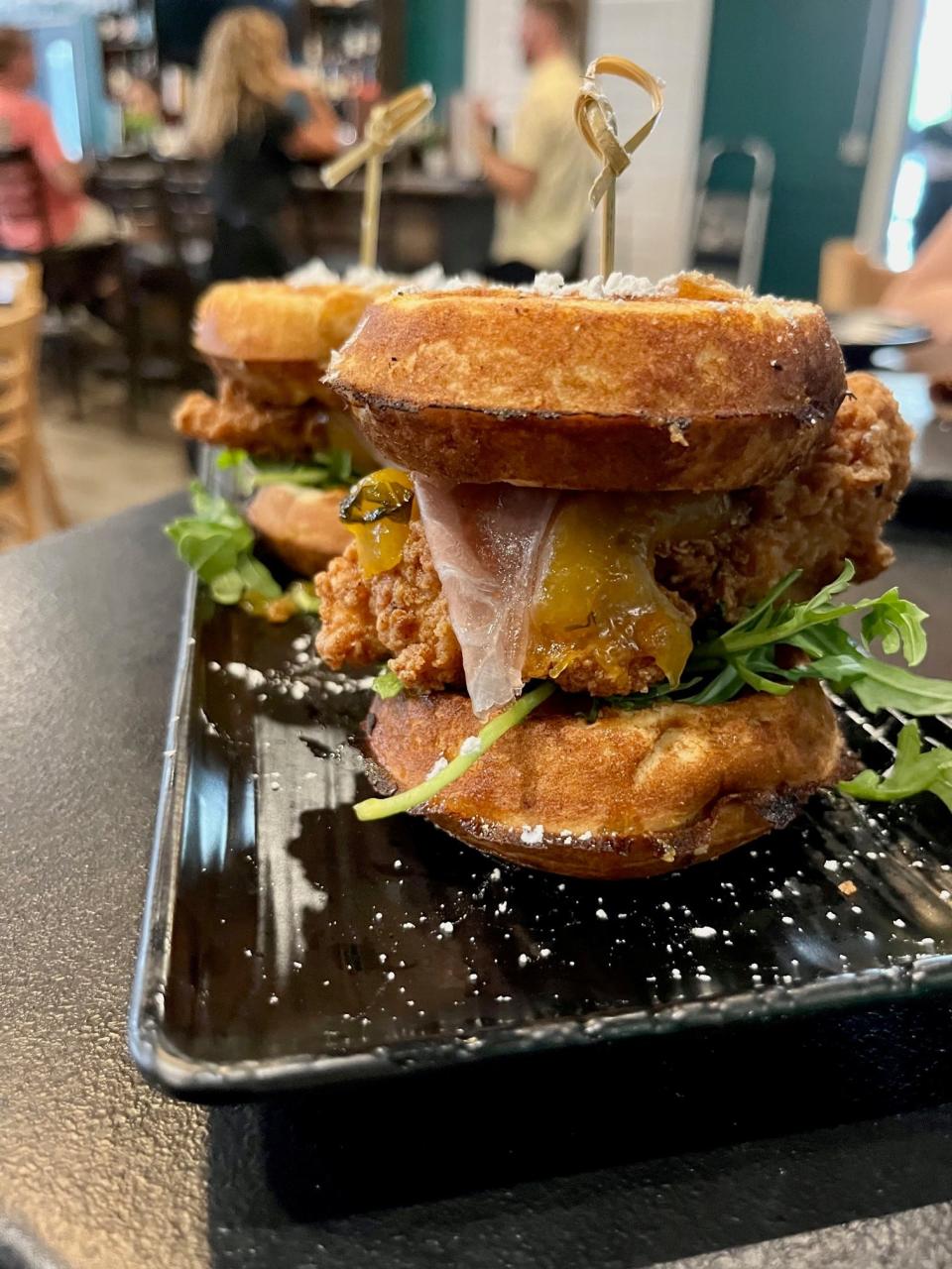 Front Porch Social's chicken & waffle sliders are served with arugula, peach compote, fennel honey, fig butter and clove syrup.