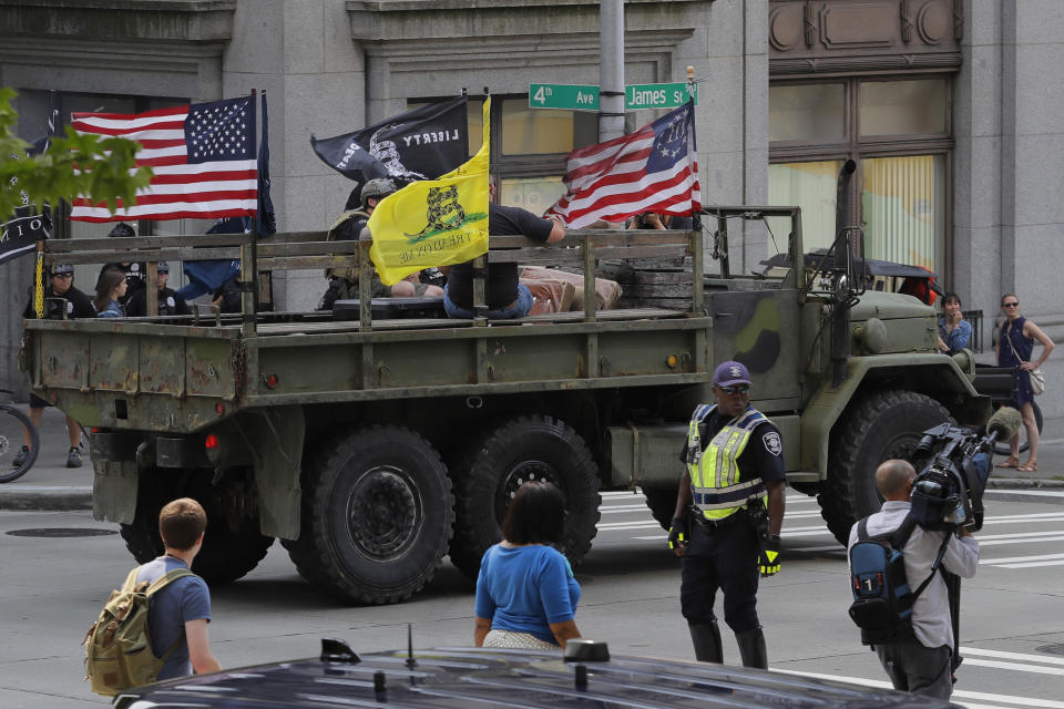 Supporters of a rally held by members of Patriot Prayer and other groups advocating for gun rights ride in a military-style truck, Saturday, Aug. 18, 2018, near City Hall in Seattle. (AP Photo/Ted S. Warren)