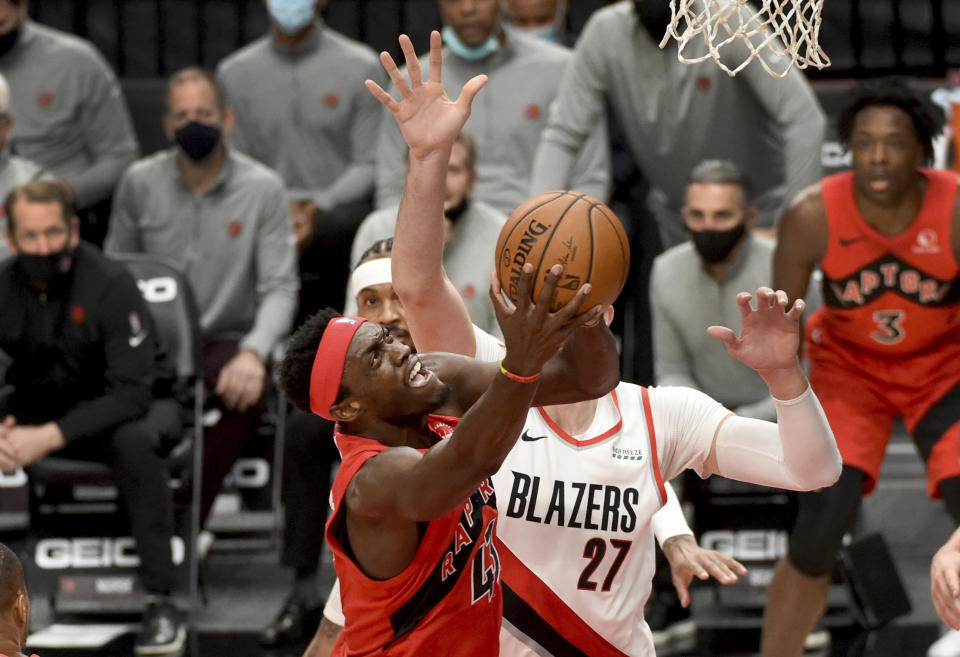 Toronto Raptors forward Pascal Siakam, left, drives to the basket against Portland Trail Blazers center Jusuf Nurkic, right, during the first half of an NBA basketball game in Portland, Ore., Monday, Jan. 11, 2021. (AP Photo/Steve Dykes)