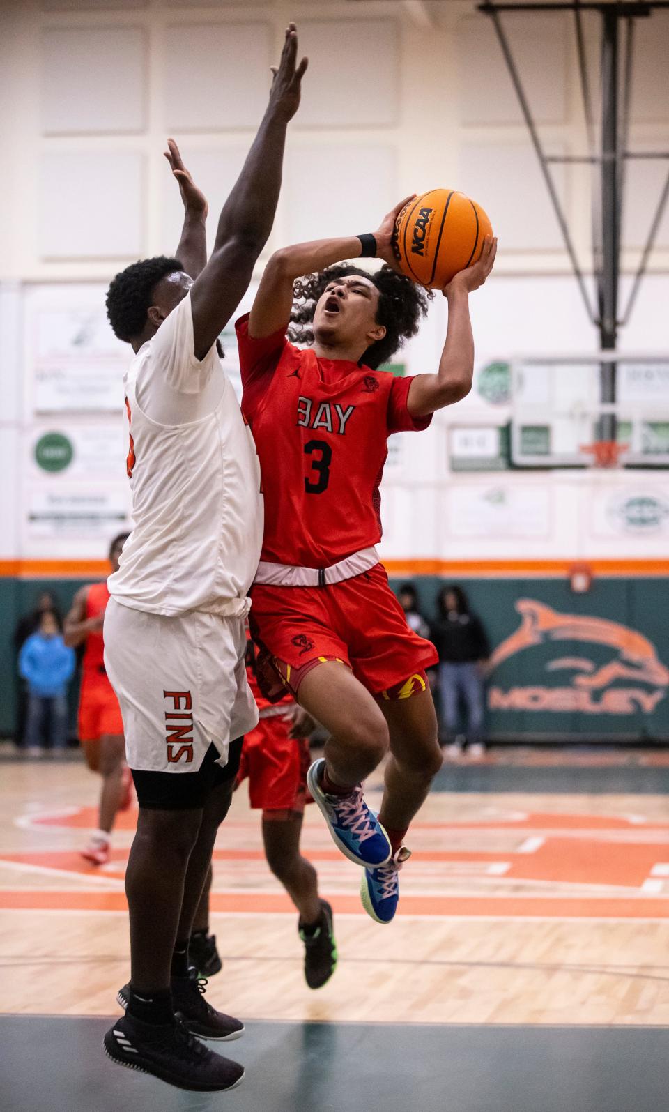 Bay High junior Keigi Lilly drives past Mosley junior Randy Pittman. Mosley hosted Bay in a boys basketball game Friday, January 14, 2022. Bay left with the win, 58-46.