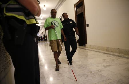 A protester is escorted by police away from a demonstration outside Senate Majority Leader Mitch McConnell's constituent office after Senate Republicans unveiled their healthcare bill in Washington, U.S., June 22, 2017 REUTERS/Kevin Lamarque