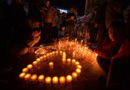 Chinese mourners light candles at the scene of the terror attack at the main train station in Kunming, Yunnan Province on March 2, 2014