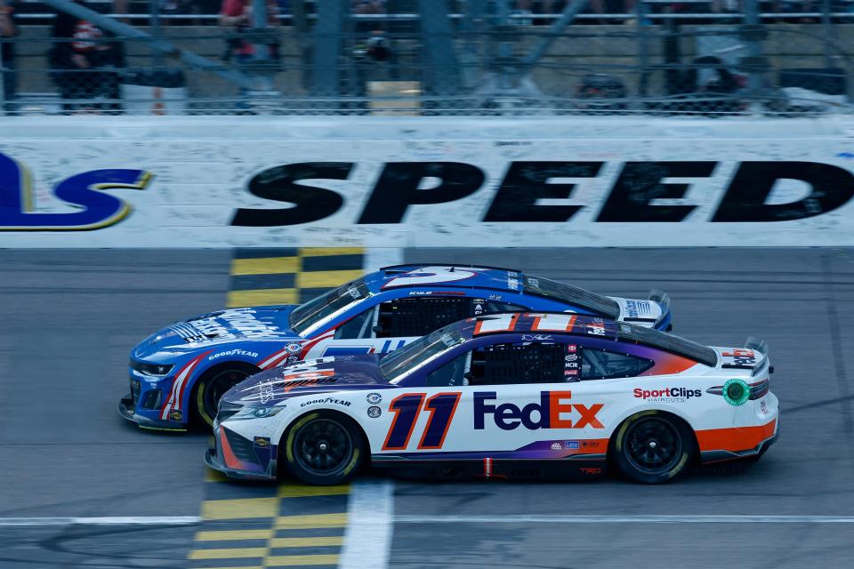 Denny Hamlin (11) attempts to take the lead from driver Kyle Larson (5) during the NASCAR Cup Series race at Kansas Speedway on May 7, 2023.