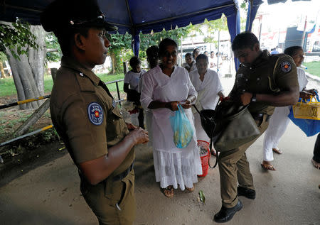 Police officers search the bags of the worshipers at an entrance of the Kelaniya Buddhist temple during Vesak Day, commemorating the birth, enlightenment and death of Buddha, in Colombo, Sri Lanka May 18, 2019. REUTERS/Dinuka Liyanawatte