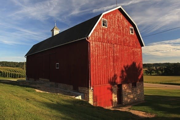 The Weber barn, north of St. Donatus, is a large red barn with a single cupola, two small upper windows and a limestone foundation.