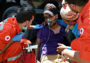 <p>A man is treated for smoke inhalation by Red Cross members after a fire tore through a camp for Syrian refugees, near the town of Qab Elias, in Lebanon’s Bekaa Valley, July 2, 2017. (Hassan Abdallah/Reuters) </p>