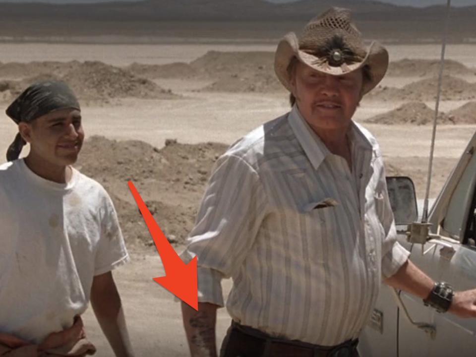 red arrow pointing at mr sir's rattlesnake tattoo in a scene from holes
