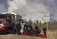 Fire Rescue crews unload in preparation to battle a wildfire in Fort McMurray, Alta., on Thursday, May 5, 2016. THE CANADIAN PRESS/Jason Franson