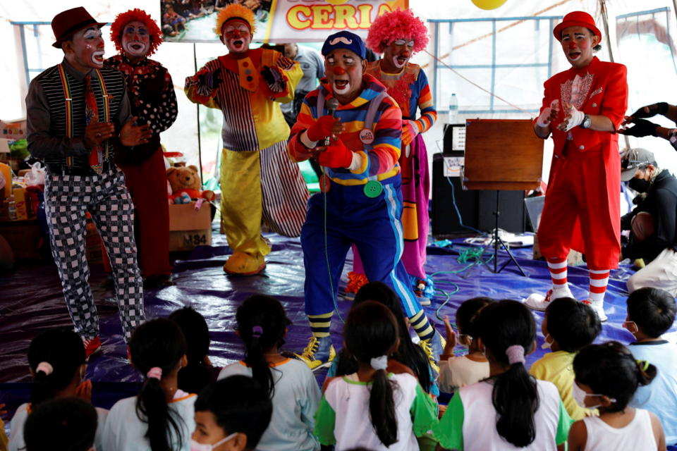 Dedy Rachmanto, 53, known as Dedy Delon who is the founder of a clowns' association called Aku Badut Indonesia or 'I Indonesia Clown', perform a show with other clowns to cheer the children who were affected by the eruption of Mount Semeru volcano, inside a temporary tent in Penanggal, Candipuro district, Lumajang, East Java province, Indonesia, December 9, 2021. REUTERS/Willy Kurniawan REFILE- QUALITY REPEAT