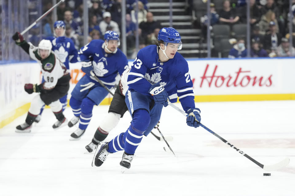 Toronto Maple Leafs' Matthew Knies, front, brings the puck forward against the Arizona Coyotes during second-period NHL hockey game action in Toronto, Thursday, Feb. 29, 2024. (Chris Young/The Canadian Press via AP)
