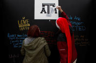 People write on a message wall during the "Aggies United" official school event outside Kyle Field at Texas A&M University, before a separate event not sanctioned by the school on campus where white nationalist leader Richard Spencer of the National Policy Institute is due to speak, in College Station, Texas, U.S. December 6, 2016. REUTERS/Spencer Selvidge