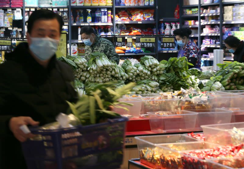 Man wearing face mask shops for vegetables inside a fresh food store following an outbreak of the novel coronavirus in Wuhan