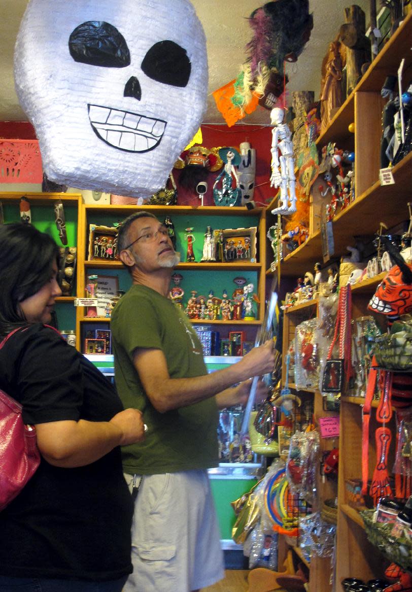 In this May 8, 2013 photo, artwork is shown at Masks y Mas, an Albuquerque shop that sells 'Day of the Dead' art year round. Disney announced Tuesday that it was a withdrawing a "Dia de los Muertos" trademark request it made to the U.S. Patent and Trademark Office amid uproar on social media from Latino activists, writer and artists. Disney had sought to secure naming right for an upcoming animated movie inspired by the holiday. Critics said the move to trademark a cultural holiday was insensitive. (AP Photo/Russell Contreras)