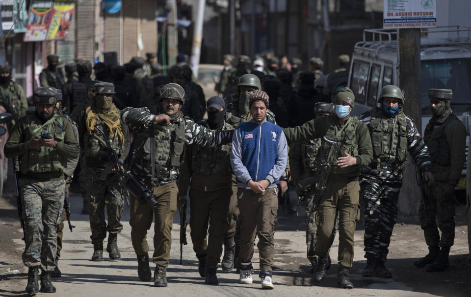 Indian paramilitary soldiers detain a Kashmiri for questioning near the site of a shootout in Srinagar, Indian controlled Kashmir, Friday, Feb. 19, 2021. Anti-India rebels in Indian-controlled Kashmir killed two police officers in an attack Friday in the disputed region’s main city, officials said. Elsewhere in the Himalayan region, three suspected rebels and a policeman were killed in two gunbattles. (AP Photo/Mukhtar Khan)