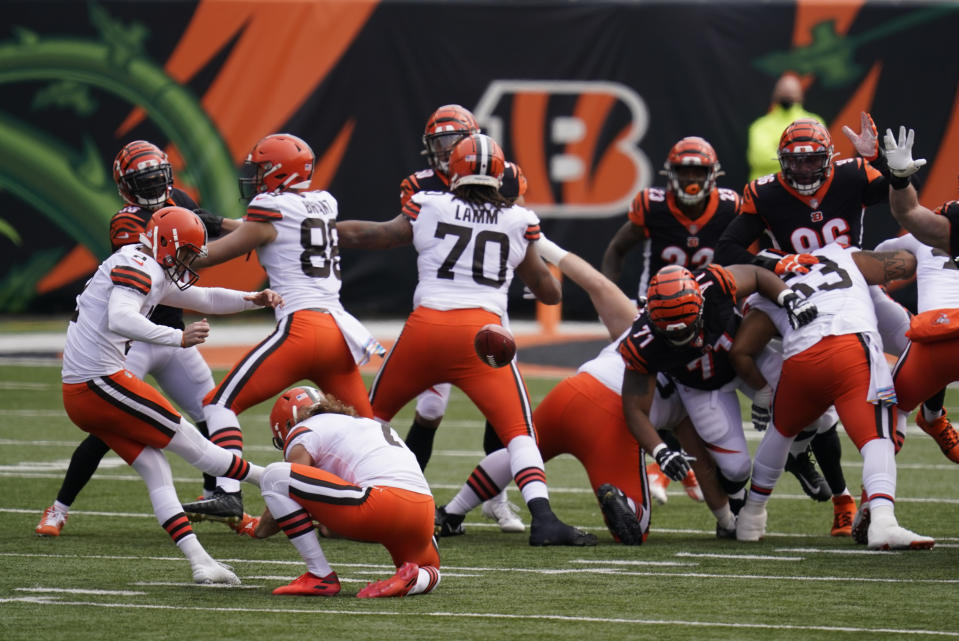 Cleveland Browns kicker Cody Parkey (2) boots a field goal out of the hold of Jamie Gillan (7) during the first half of an NFL football game against the Cincinnati Bengals, Sunday, Oct. 25, 2020, in Cincinnati. (AP Photo/Michael Conroy)