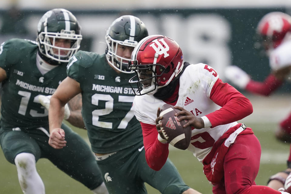 Indiana quarterback Dexter Williams II (5) is chased by Michigan State linebacker Cal Haladay (27) during the second half of an NCAA college football game, Saturday, Nov. 19, 2022, in East Lansing, Mich. (AP Photo/Carlos Osorio)
