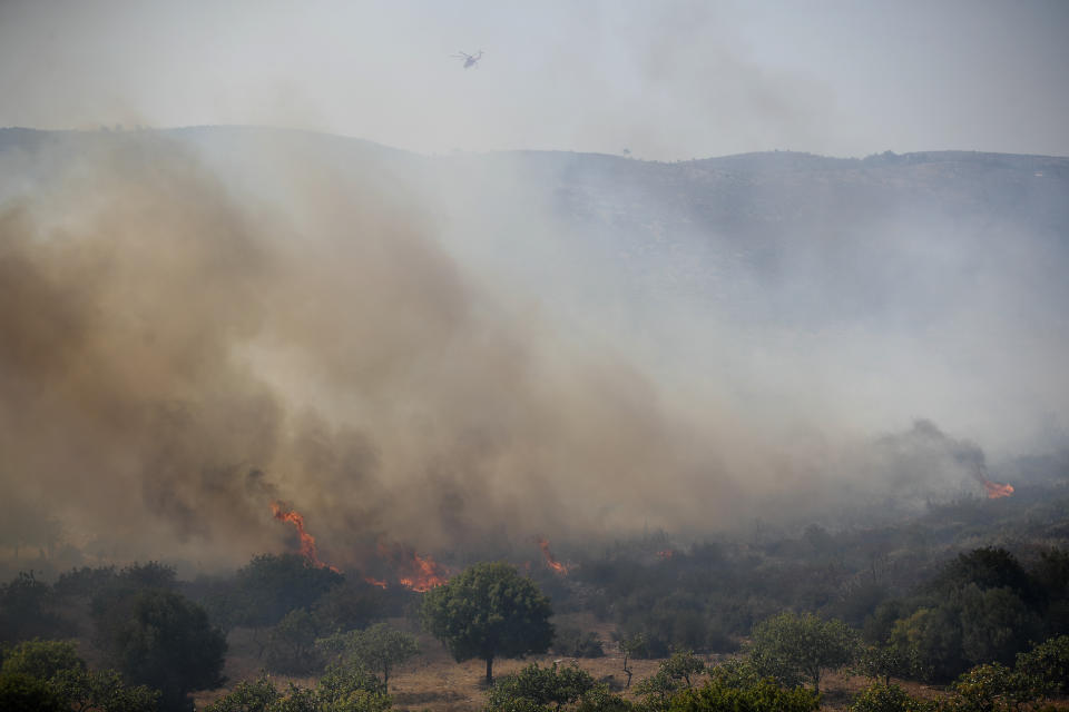 A cloud of smoke raises from a forest fire at an area of Marathon town, northeast of Athens, on Saturday, Aug. 10, 2019. Firefighters fight against a fire at the city of Marathon, as a heatwave that has gripped most of Greece, combined with persistent high winds, has helped ignite dozens of fires. (AP Photo/Thanassis Stavrakis)